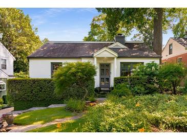 Charming home with manicured front yard, trimmed hedges, and gray front door at 522 Trabert Nw Ave, Atlanta, GA 30309