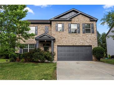 Charming two-story brick home featuring a two-car garage and a well-maintained front yard with lush landscaping at 468 Lake Ridge Ln, Fairburn, GA 30213
