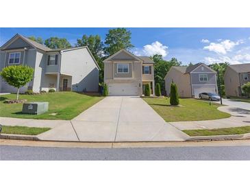 Charming two-story home with a stone-accented facade, well-manicured lawn, and a concrete driveway at 104 Auburn Crossing Way, Auburn, GA 30011