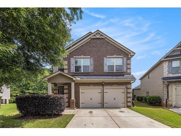 Charming brick two-story home featuring a two-car garage and manicured lawn at 2149 Apple Orchard Way, Austell, GA 30168