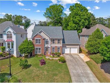 Charming home with a manicured lawn, a two-car garage, and a mix of brick and siding exterior at 2325 Walnut Grove Way, Suwanee, GA 30024