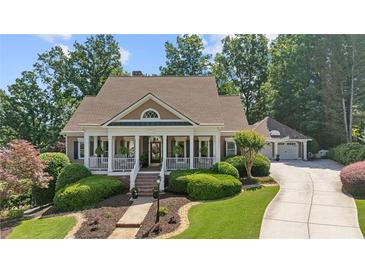 Charming home with a welcoming front porch, manicured landscaping, and a long driveway leading to a two-car garage at 3902 Butterstream Way, Kennesaw, GA 30144