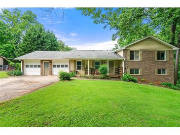 Charming two-story home with brick and siding exterior and a well-manicured lawn, plus a two-car garage at 486 Buttercup Trl, Lawrenceville, GA 30046
