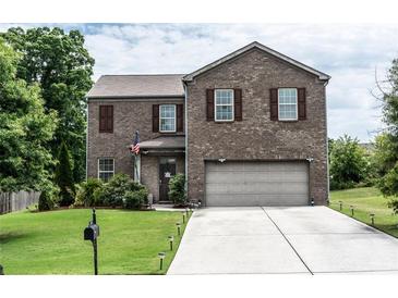 Charming two-story brick home featuring a well-maintained front yard, attached garage, and traditional design at 8553 Braylen Manor Dr, Douglasville, GA 30134
