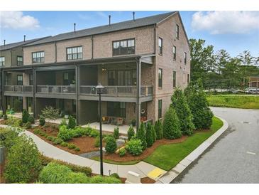 Stunning brick townhome with covered patios and manicured landscaping, located on a corner lot at 6460 Cortland Walk, Alpharetta, GA 30005