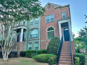 Two-story brick townhome featuring a charming entrance with landscaped front yard at 4875 Carre Way, Alpharetta, GA 30022