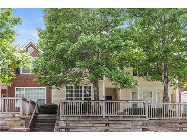 Inviting two-story townhome featuring mature trees and a charming wood porch and facade at 112 Hawkeye Ln, Conyers, GA 30012