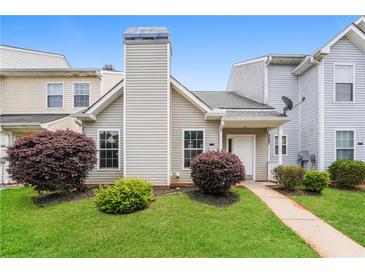 Charming townhouse featuring lush front lawn and neatly trimmed shrubbery at 5867 Trent Walk Dr, Lithonia, GA 30038