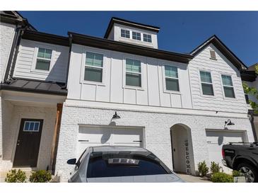 Charming townhouse with white brick and siding and attached garages at 82 Auburn Run Ln, Auburn, GA 30011