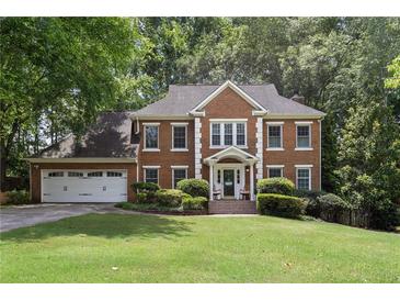 Beautiful two-story brick home with a well-manicured lawn and a two-car garage at 4648 Equestrian Way, Atlanta, GA 30338