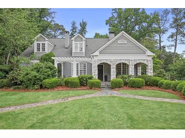 Charming two-story home with stone accents, inviting walkway, and lush landscaping at 635 Wilson Nw Rd, Atlanta, GA 30318