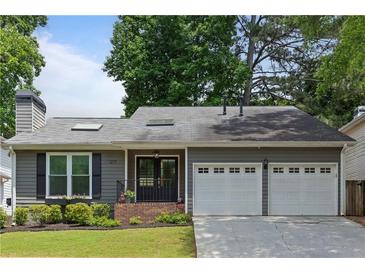 Charming gray single-story home with a well-manicured front yard and a convenient two-car garage at 1217 Club Walk Ne Dr, Brookhaven, GA 30319