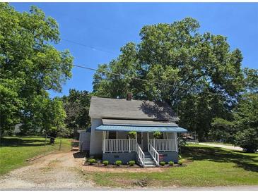 Charming single-story home with a quaint front porch and mature trees, offering a cozy and inviting curb appeal at 5108 Hackett Ne St, Covington, GA 30014