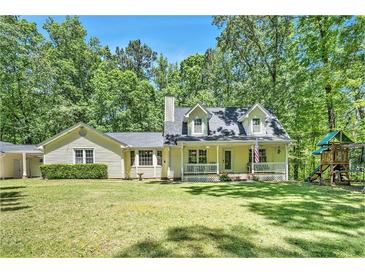 Charming home with well-manicured lawn, inviting front porch, and playset in a beautiful, wooded setting at 4840 Chapel Hill Rd, Douglasville, GA 30135