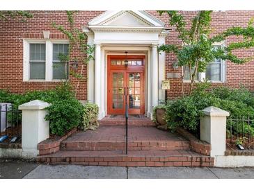Charming brick building entrance featuring a striking red door with white columns, steps, and manicured landscaping at 733 Frederica Ne St # 17, Atlanta, GA 30306