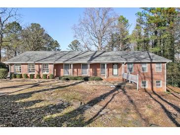 Charming brick home with a well-manicured lawn, complemented by mature trees and a welcoming entrance at 1110 Upper Hembree Rd, Roswell, GA 30076