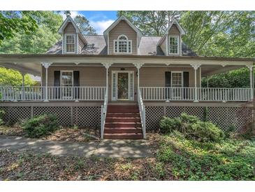 Charming two-story home featuring a welcoming front porch, neutral siding and well-maintained landscaping at 143 Cotton Mill Dr, Hiram, GA 30141