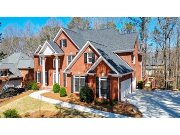 Beautiful brick two-story home with manicured landscaping, gray roof, and black shutters at 1105 River Laurel Dr, Suwanee, GA 30024