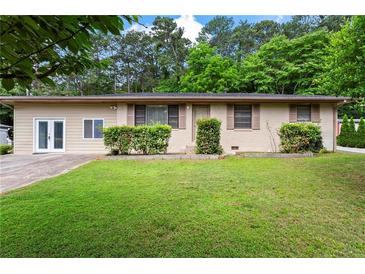 Charming single-story home featuring a well-maintained lawn and lush greenery at 624 Lyle Se Dr, Marietta, GA 30067