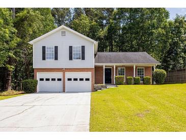 Charming two-story home with attached two-car garage and well-manicured lawn and black window shutters at 6541 Lazy Creek Ct, Lithonia, GA 30058