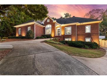 Beautiful brick home featuring a well-manicured lawn, mature trees, and an elegant driveway at 248 Montrose Dr, Mcdonough, GA 30253