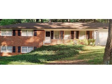Charming brick home with well-kept lawn and mature trees, enhancing its curb appeal at 5582 Brady Dr, Stone Mountain, GA 30087
