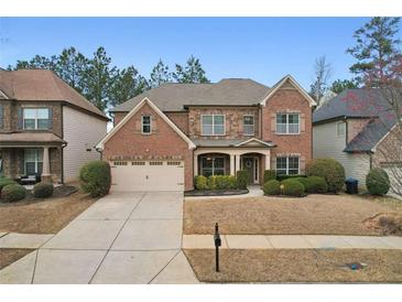 Charming two-story brick home featuring a well-manicured front yard and attached two-car garage at 2126 Roberts View Trl, Buford, GA 30519