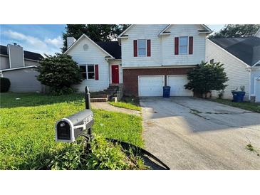 Charming two-story home with an attached garage and a well-manicured front lawn at 5415 Twin Lakes Dr, Atlanta, GA 30349