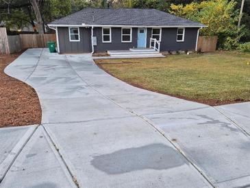 Charming single-story home with a freshly paved driveway and welcoming light blue front door at 2127 Whites Mill Rd, Decatur, GA 30032