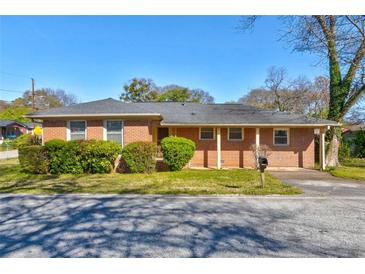 Charming brick home with a well-maintained lawn and neatly trimmed bushes enhancing its curb appeal at 5136 Jones Rd, Forest Park, GA 30297