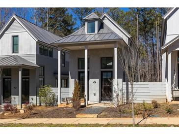 Charming gray cottage style home with inviting front porch and manicured landscaping at 135 Mado Ln, Chattahoochee Hills, GA 30268