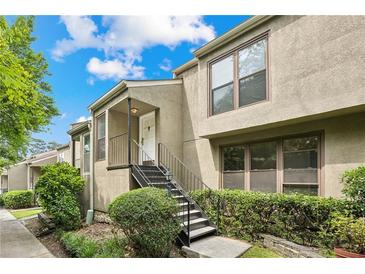 Two-story condo featuring a cozy front porch with stairs leading to the entrance and manicured landscaping at 1719 Woodcliff Ne Ct, Atlanta, GA 30329