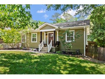 Charming single-story home with green siding, a landscaped front yard, and inviting front porch with bench seating at 1734 8Th St, Atlanta, GA 30341
