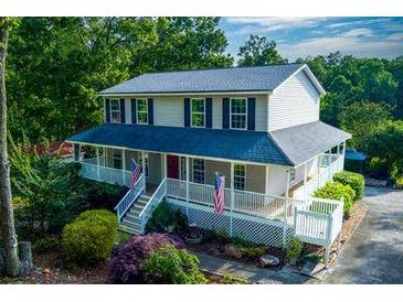 Charming two-story home featuring a spacious wrap-around porch and a well-maintained yard in a wooded setting at 2024 Lower Burris Road Rd, Canton, GA 30114