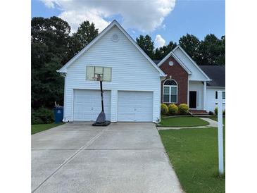 Traditional home featuring a two-car garage and a well-maintained front lawn at 2504 Dalesford Ct, Dacula, GA 30019