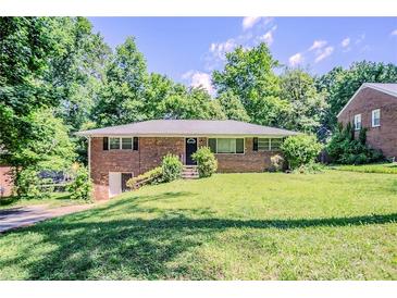 Traditional brick ranch-style home featuring a well-manicured lawn with lush greenery, and inviting curb appeal at 2201 Bollingbrook Drive, Atlanta, GA 30311