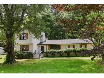 Charming home with a lush green lawn and mature trees providing shade and character at 3308 Quail Run Sw Sw Run, Marietta, GA 30008