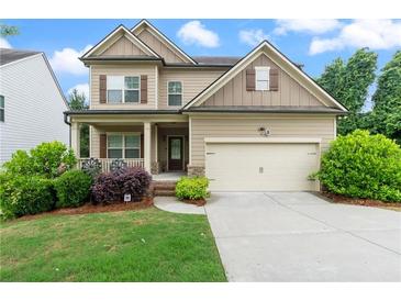 Charming two-story home featuring a two-car garage, inviting front porch, and well-manicured landscaping at 1537 Maplecliff Way, Sugar Hill, GA 30518