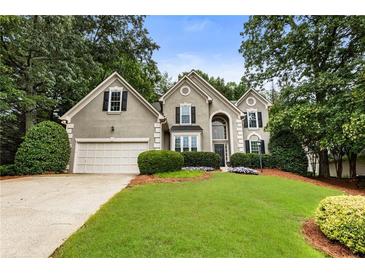 Charming two-story home with a well-manicured lawn, beautiful landscaping, and inviting curb appeal at 5860 Fairway View Dr, Suwanee, GA 30024
