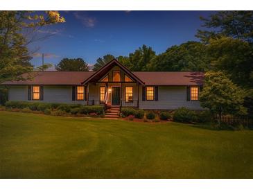 Charming single-story home featuring a well-manicured lawn and inviting entrance at dusk at 3769 Bay Creek Church Rd, Loganville, GA 30052