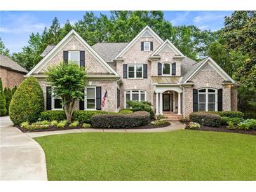 Charming two-story brick home with lush landscaping and a well-manicured lawn at 8970 Moor Park Run, Duluth, GA 30097