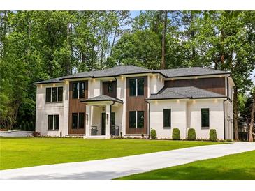 Stunning two-story home with white brick, wood accents, lush lawn, and a concrete driveway at 942 Fairfield, Marietta, GA 30068