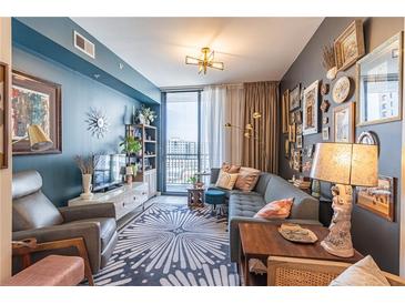Comfortable living room featuring a modern sectional, city views, and stylish decor at 3040 Peachtree Nw Rd # 1013, Atlanta, GA 30305