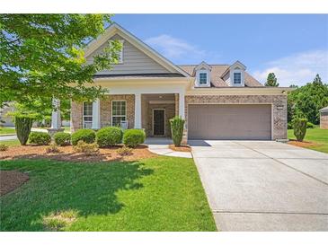 Charming brick home with a well-manicured lawn and a two-car garage at 2920 Farmstead Way, Suwanee, GA 30024