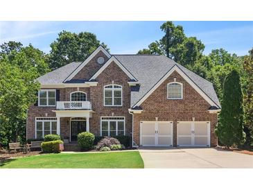 Charming brick home with a manicured lawn, mature trees, and an attached two-car garage at 5059 Belair Bluff Se Ct, Smyrna, GA 30126