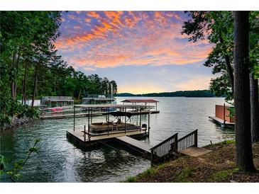 Picturesque lake view with a boat dock and beautiful sunset sky at 7875 Robin Rd, Cumming, GA 30041