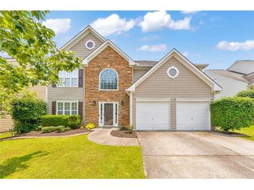 Charming two-story home featuring a stone facade, well-manicured lawn, and a two-car garage at 3816 Harris Nw Blvd, Kennesaw, GA 30144
