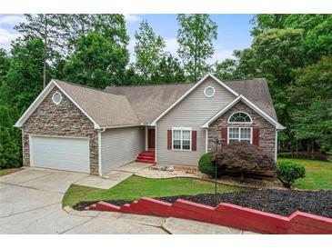Charming one-story home featuring stone accents, a two-car garage, and mature landscaping at 2701 Windsor Nw Ct, Kennesaw, GA 30144