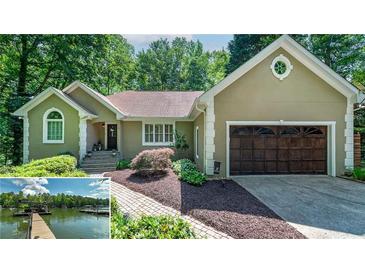Charming one-story home with manicured landscaping, a two-car garage, and views of the lake at 2825 Lake Ct, Cumming, GA 30041