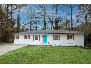 Charming brick ranch with a striking turquoise door and well-manicured lawn at 3893 Bonnie Se Ln, Atlanta, GA 30354